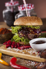 Home made burgers on wooden background.