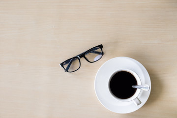 Black coffee cup on the wooden background with men equipment. topview  with copy space.