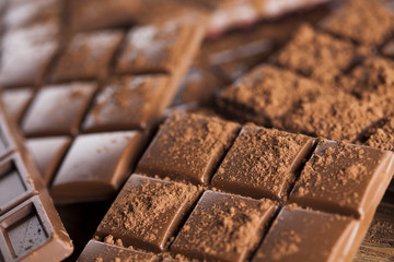 Dark homemade chocolate bars and cocoa pod on wooden