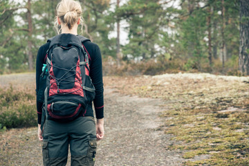 Hiking girl with backpack in forest