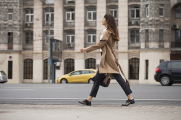 Naklejka premium Portrait of a young beautiful woman in beige coat