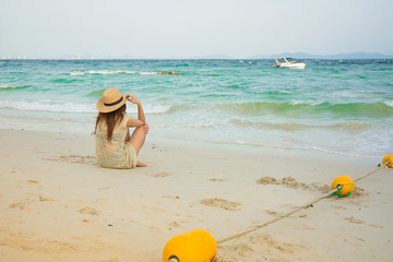 Fashion  of asian beautiful girl  with hippie outfit and hat outdoors at sunset on the sea. Soft warm color tone. Boho lifestyle. Bohemian Style.