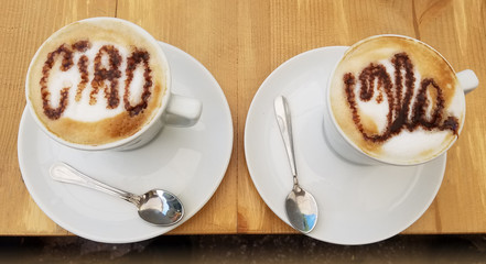 Delicious cappuccino coffee cups with creamy froth design with greetings
