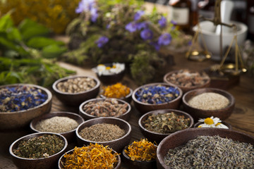 Natural medicine, herbs, mortar on wooden table background