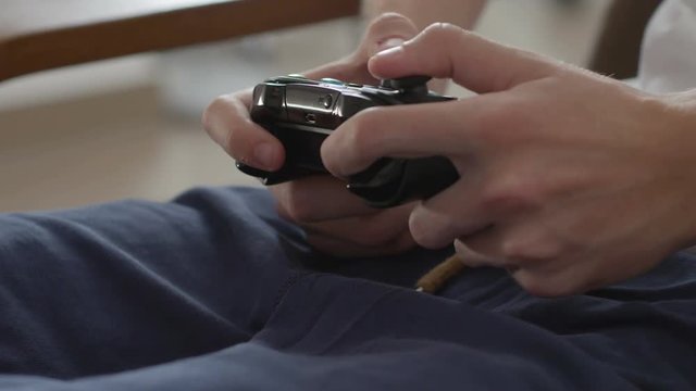 Teenage boy using game pad controller to play video games, gaming and entertainment concept