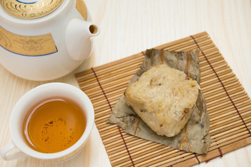 traditional Chinese glutinous rice dumpling with cup of tea and teapot horizontal composition