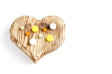 wooden texture heart with pills on the background of the wooden planks. the idea of ecology natural treatment