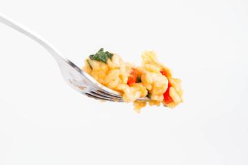 Risotto with chicken, tomatoes, bell pepper, onion, garlic and parsley on a fork on a white background © teine