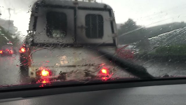 POV driving in hard rain on the street in Bangkok, Raining on windshield.
