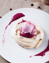 Meringue with berry ice cream on a white plate