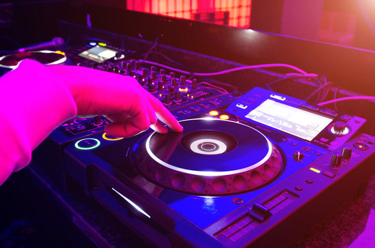 Dj mixes the track in nightclub at party