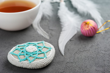 Cup of tea and crocheted pebble