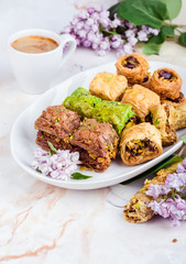 Mixed  baklava in white plate on marble background. Ramadan food, turkish arabian cuisine. Selective focus