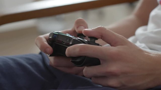Teenage boy using game pad controller to play video games, in the end throwing the controller, close up