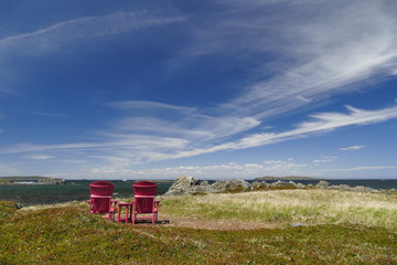 empty red chairs by ocean