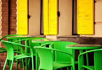 color cafe in old european city with yellow windows and green chairs