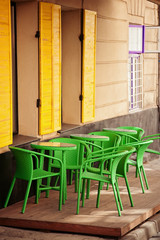 color cafe in old european city with yellow windows and green chairs 