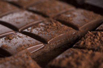Dark homemade chocolate bars and cocoa pod on wooden