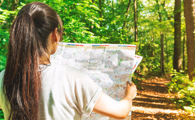 Woman in reading a map in the forest