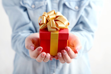 Female hands holding gift box with ribbon