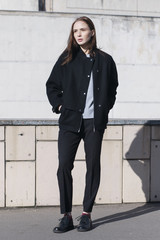 young female fashion model in black bomber jacket, gray shirt and black boots - street style