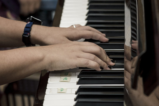 Manos de mujer tocando el piano. Reproducción de música por un pianista. Manos en el piano.