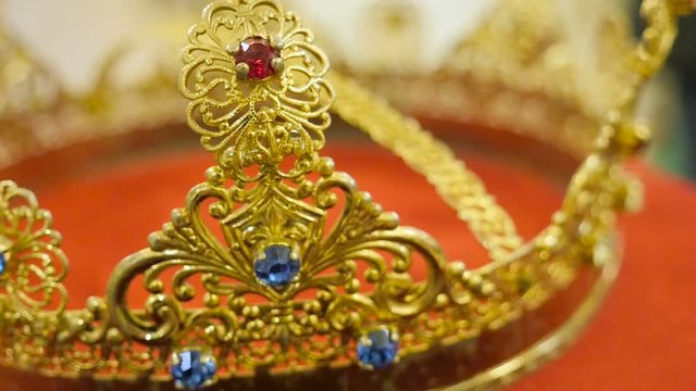 Close up of gold wedding crowns with sapfire, rubin and brilliant prepared for ceremony of marriage in a church.