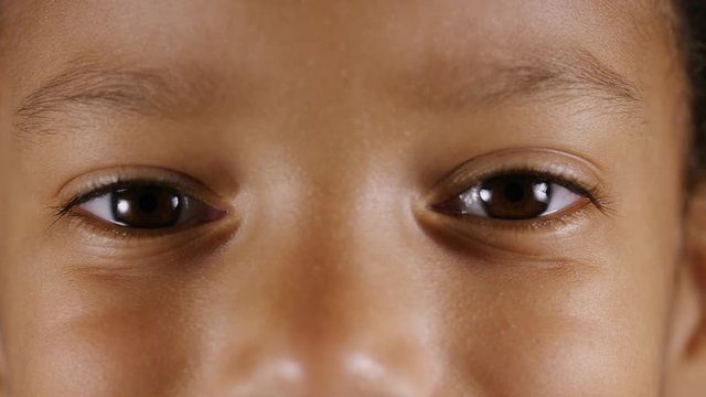 Close up of a child's eyes as she looks into camera and smiles