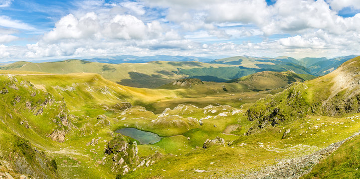Landscape panorama with a blue sky and white clouds above the Carpathian mountains in Romania