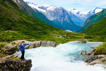 Naklejka premium Tourist woman by Videfossen Waterfall in Norway
