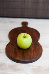 Ripe green apples with slices on a wooden cutting board, isolated  white