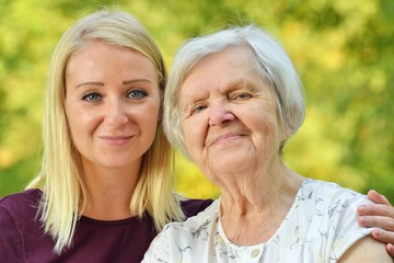 Grandmother and granddaughter. Young woman carefully takes care