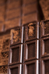 Dark homemade chocolate bars and cocoa pod on wooden