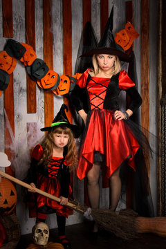 halloween witches in costumes with broom