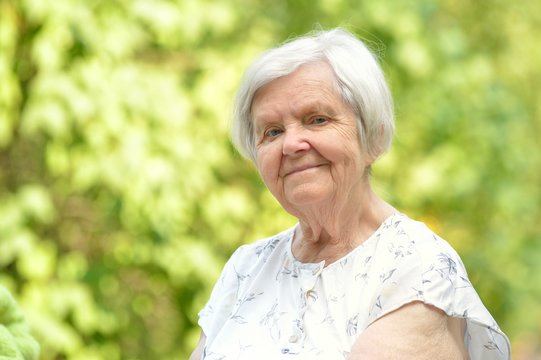 Senior woman smiling in park.