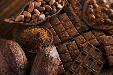 Dark homemade chocolate bars and cocoa pod on wooden