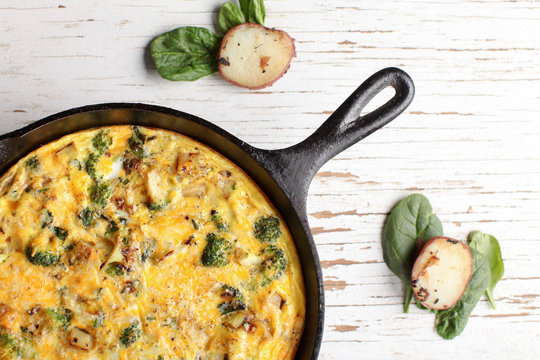 Baked egg frittata with spinach, cheese, broccoli, red potatoes, bacon, milk, and spinach top horizontal view