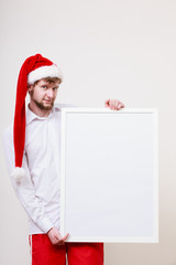Man in santa hat with blank banner. Copy space.