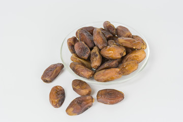 dried dates in the dish on white background.