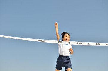 走る女の子（体操服、ゴールテープ、青空）