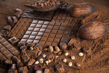Dark homemade chocolate bars and cocoa pod on wooden