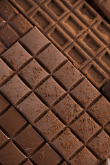 Dark homemade chocolate bars and cocoa pod on wooden