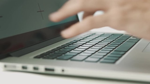 Woman working on laptop at home interier near the window. Hands and fingers on the keyboard close-up