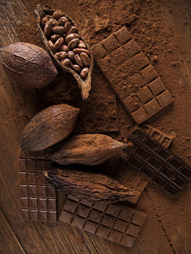 Chocolate bar, candy sweet, cacao beans and powder on wooden bac