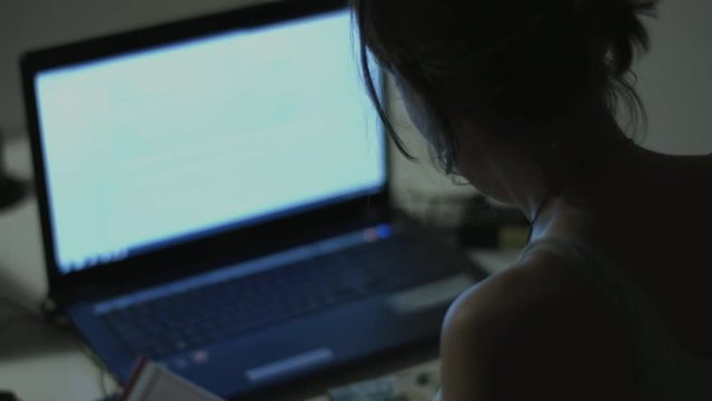 Woman working on laptop at home interier near the window. Hands and fingers on the keyboard close-up