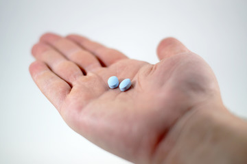 Male hand with blue pills