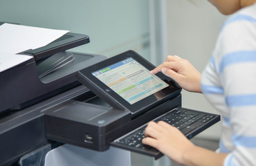 Business woman is using the printer to scanning and printing document