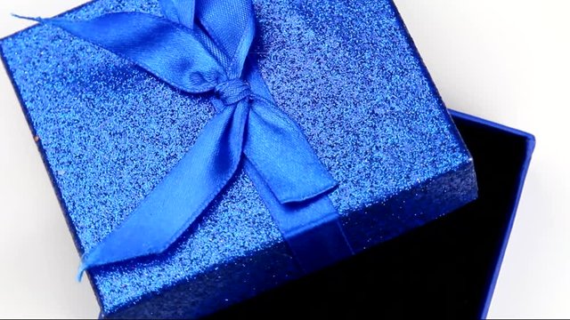 Rotating blue gift box on a paper background