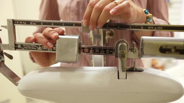 Girl measuring her weight on the scale