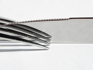 Naklejka premium Knife and fork reflection on white background